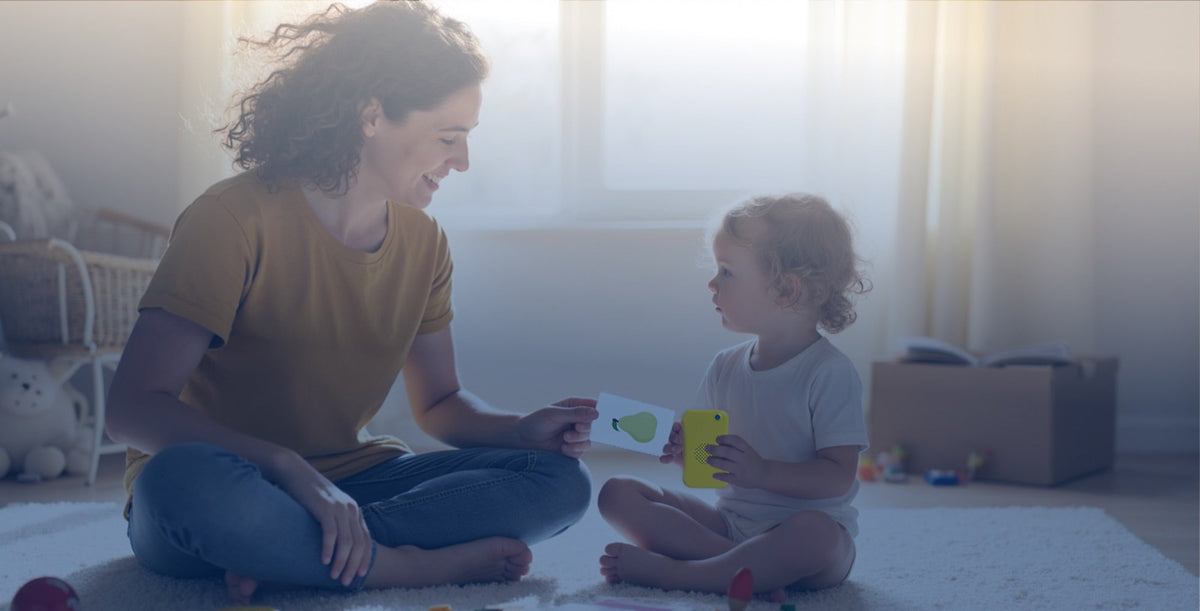 A mother and her toddler playing with a My First Words card and Talkido Mio
